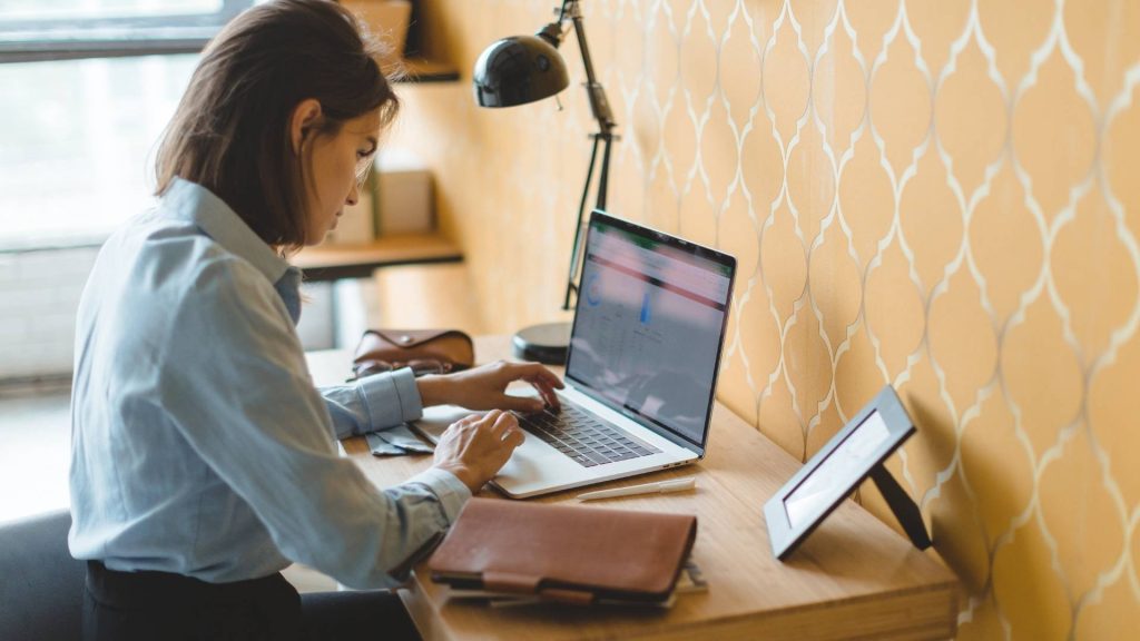 Mujer en un escritorio, usando un laptop de APG mientras trabaja