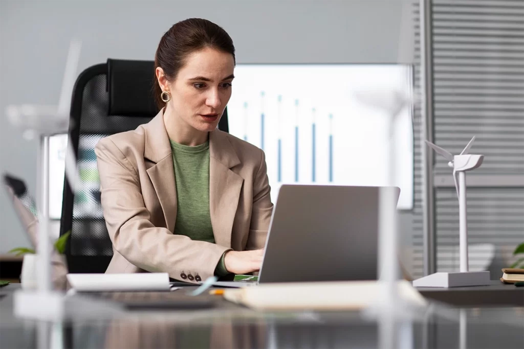 Profesional de recursos humanos gestionando digitalización en laptop desde oficina.