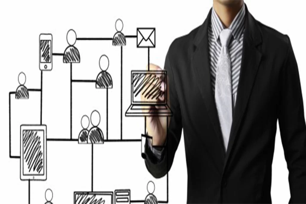 Director de TI señalando diagrama de red con dispositivos y usuarios conectados.