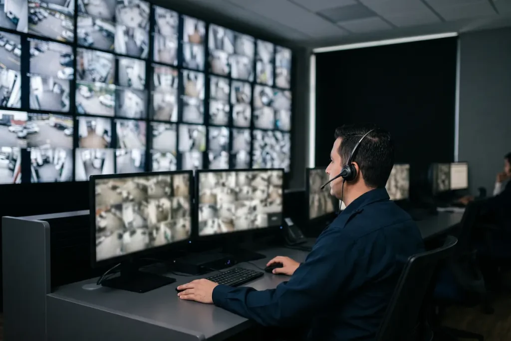 Operador supervisando pantallas de seguridad CCTV en una central de monitoreo mediante renting tecnológico.